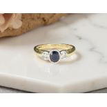 An 18ct yellow gold sapphire and two stone diamond ring, size M/N.