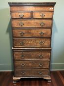 A reproduction yew wood and satin wood banded eight drawer chest on chest in th George III style,