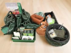 Assorted new gardening supplies, several watering cans, hanging baskets, bamboo, twine,