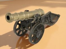 A cast iron and brass model cannon with carriage,