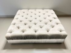 A large contemporary square footstool in deep buttoned upholstery,