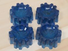 A set of four blue ribbed glass piano insulators