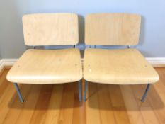 A pair of Ikea laminated wood low chairs on metal legs designed by Jonas Karlsson