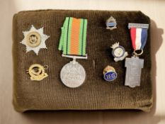 A small group of WWII and other medals on cushion