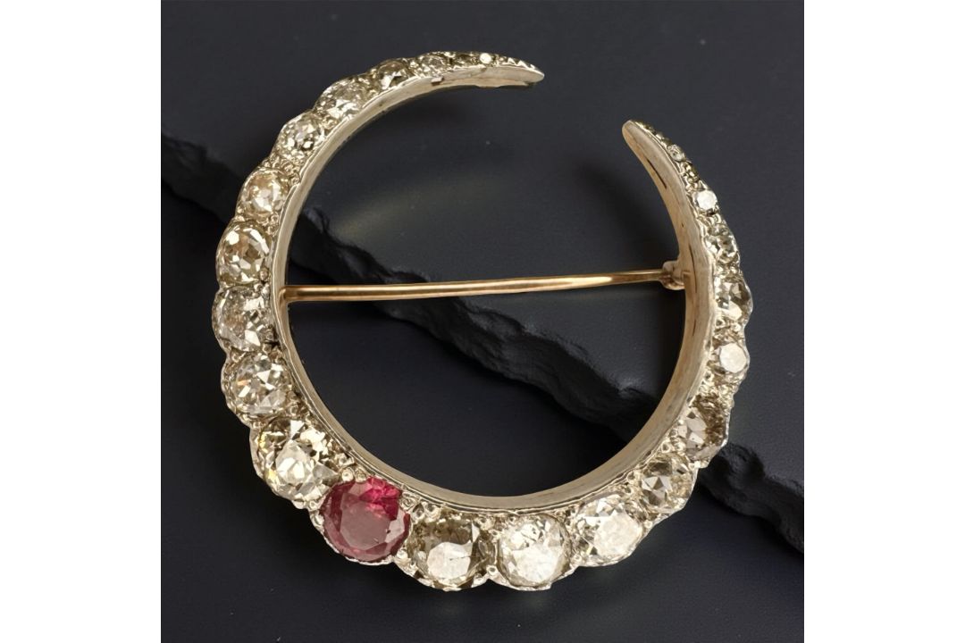 A fine quality ruby and diamond crescent brooch, set with 22 diamonds, approximately 6cts,