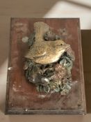 A wooden plaster wall panel depicting a bird,