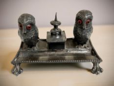 A novelty silver-plated desk stand surmounted by a pair of owls with glass-inset eyes,