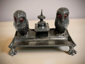 A novelty silver-plated desk stand surmounted by a pair of owls with glass-inset eyes,