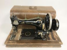 An antique hand sewing machine in wooden case
