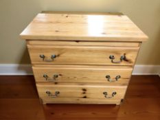 A modern pine effect three drawer chest,
