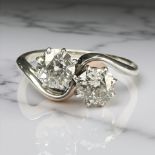 An antique platinum two stone cross-over diamond ring, approximately 1ct, size J.