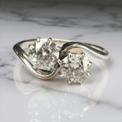 An antique platinum two stone cross-over diamond ring, approximately 1ct, size J.