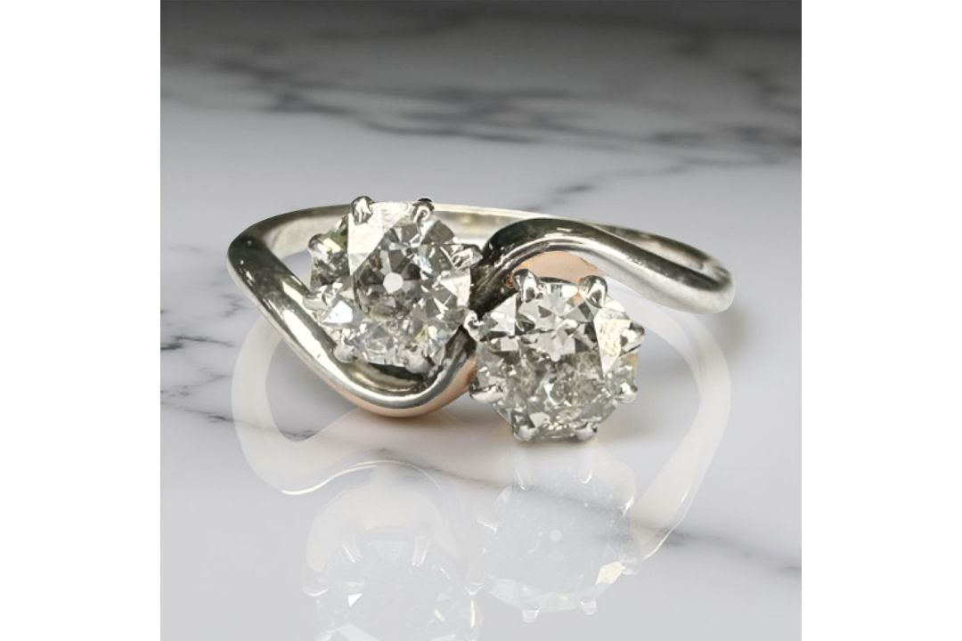 An antique platinum two stone cross-over diamond ring, approximately 1ct, size J.