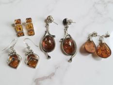 Four pairs of silver and amber earrings