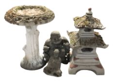 A weathered concrete garden pagoda,