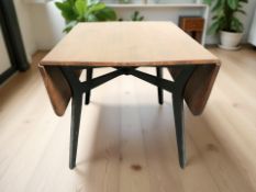 A 20th century teak and ebonised drop leaf table,