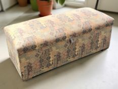 An upholstered storage ottoman, length 125 cm.