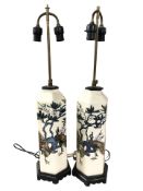 A pair of 20th century earthenware lamp bases depicting peacocks,