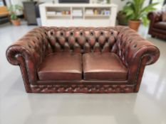 A Chesterfield oxblood buttoned leather two seater club settee, 163 cm x 90 cm x 71 cm.
