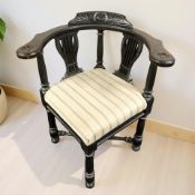 A carved and ebonised corner armchair,