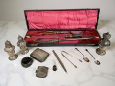 A group of silver comprising a cigarette case, vesta, spoons, tongs, a thimble, napkin ring, sifter,