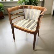 A continental mahogany horseshoe armchair on brass castors, width 66 cm.