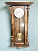 An early 20th century walnut eight day wall clock with enameled dial, with pendulum and key,