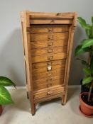 A 1920's oak tambour front office pedestal filing cabinet, fitted ten drawers internally,