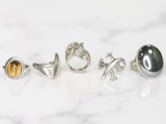 A silver lizard ring, another depicting a horse, a tiger's eye ring,