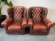 A pair of Chesterfield oxblood buttoned leather wingback armchairs, width 88 cm.