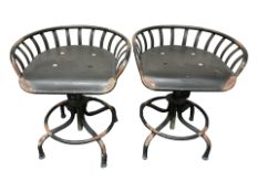 A pair of contemporary metal industrial style swivel stools.