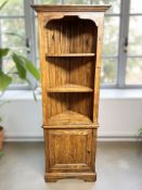 A Willis & Gambier stained pine corner shelf, fitted cupboard beneath, height 196 cm.