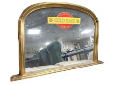 A modern gilt overmantel mirror with Wills golden flake decoration, width 120 cm.