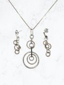 A silver two-tone hoop pendant and matching earrings