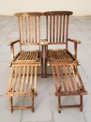 A pair of teak garden sun loungers.
