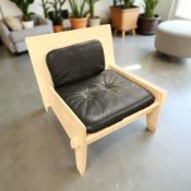 A 1990's IKEA laminated wood chair with black leather cushion, width 69 cm.