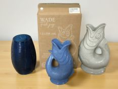 Two Wade pottery fish gluggle jugs and a ribbed blue glass vase.