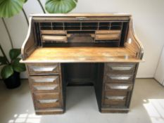 A 1920's oak tambour front twin pedestal desk, 127 cm x 78 cm x 116 cm.