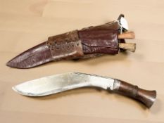 An early 20th century kukri knife in leather sheath.