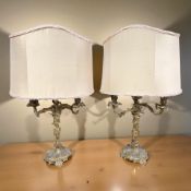 A pair of early 20th century gilt metal three sconce table lamps, with shades, height 75 cm.