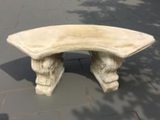 A concrete curved garden bench on classical support,