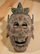 An Oriental painted wooden mask with hinged mouth,