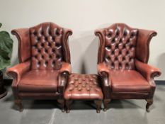 A pair of Chestefield Oxblood leather wingback armchairs and matching footstool