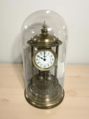 A brass torsion clock under glass dome with enamel dial signed H Samuel Manchester,