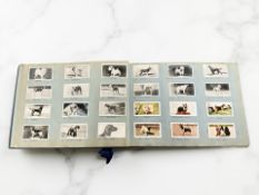 An album of reproduction Wills cigarette cards all depicting dogs,