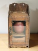 A Victorian glazed oak smoker's cabinet with ceramic jar,