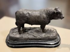 A reproduction bronze figure of a bull on stepped black marble plint,