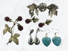 A decorative white metal brooch, a pair of earrings with turquoise cabochons stamped sterling,