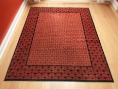 A machined geometric rug on red ground 237 cm x 170 cm