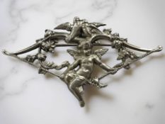 An antique silver cupid brooch